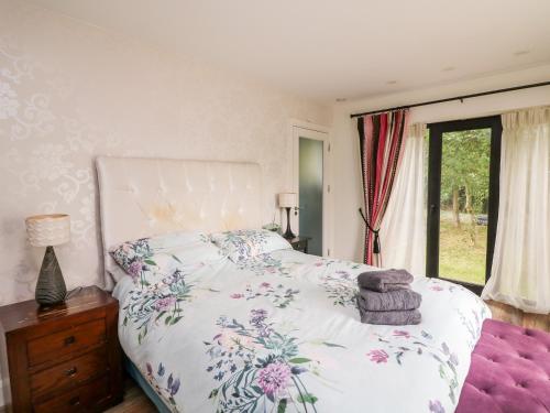 um quarto com uma cama com colcha floral em Thornhill em Enniscorthy