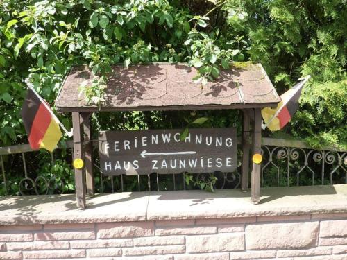 un panneau sur une clôture avec des drapeaux sur celle-ci dans l'établissement Haus Zaunwiese, à Grasellenbach