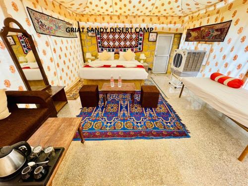 Habitación con cama, sofá y alfombra. en Griat sandy desert camp jaisalmer, en Jaisalmer