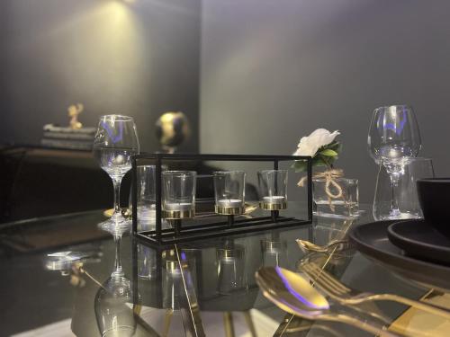 una mesa de cristal con copas de vino y una bandeja con copas en The Arc Suites en Bradford