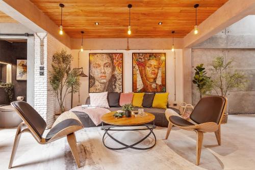 a living room with a couch and a table and chairs at Chic loft in Bangkok