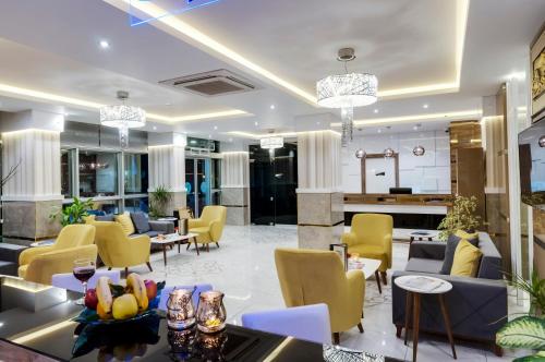 un vestíbulo de hotel con sillas y mesas amarillas en PARK YALÇIN HOTEL, en Mersin