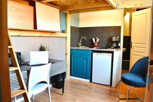 - une petite cuisine avec une table dans une petite maison dans l'établissement La Domus Lemaitre 4 - parking - Wifi - Belgique, à Bavay