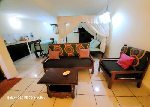 ein Wohnzimmer mit einem Sofa, Stühlen und einem Tisch in der Unterkunft LA MARINA 3 in Ambodifototra