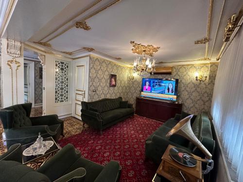 a living room with a couch and a tv at TAHTAKALE KONAK HOTEL Private & Luxury in Bursa