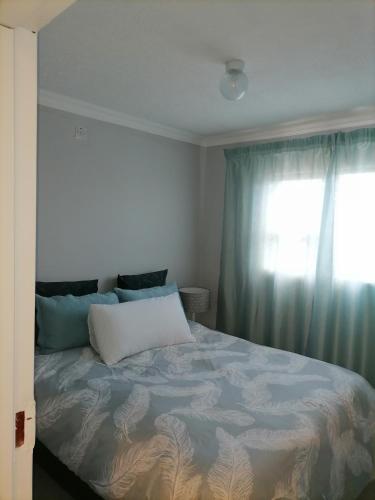 um quarto com uma cama grande e uma janela em LadyMas Oasis em Goodhope