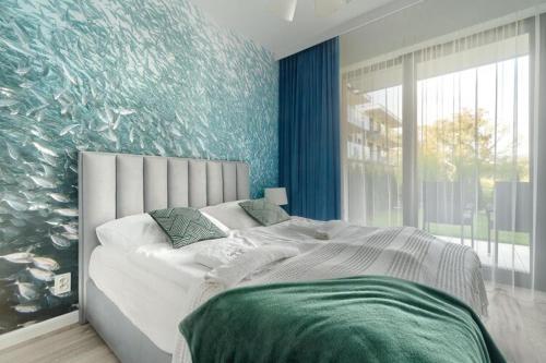 a bedroom with a large bed with a fish wall at Ground floor apartment with a garden, close to the beach, Niechorze in Niechorze