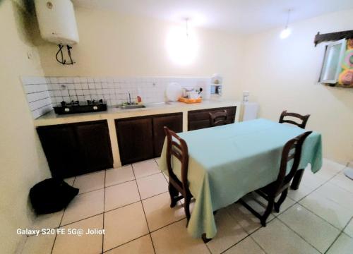 eine Küche mit einem Tisch, Stühlen und einem Waschbecken in der Unterkunft LA MARINA 3 in Ambodifototra