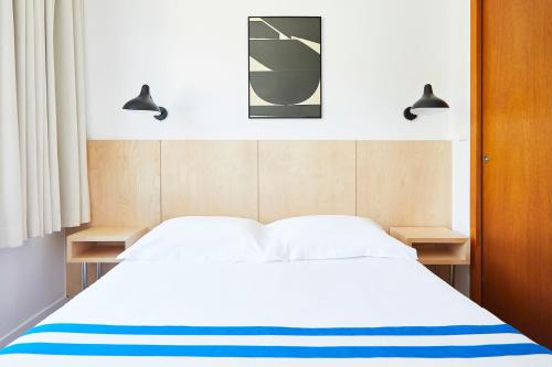 a bedroom with a white bed with two night stands at Hôtel California in Le Lavandou