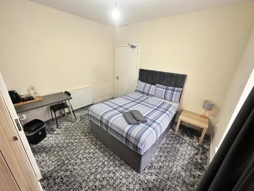 Schlafzimmer mit einem Bett, einem Schreibtisch und einem Schreibtisch in der Unterkunft IBROX GuestHouse in Glasgow