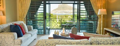 a living room with two couches and a large window at dk villas 1 Harbour View Hout Bay in Hout Bay