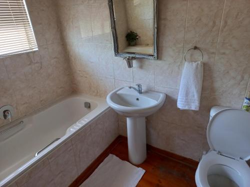 a bathroom with a sink and a tub and a toilet at Twogether House in Clarens