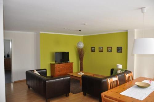 a living room with a table and chairs and a television at Ferienwohnung Guddat in Hemsbach