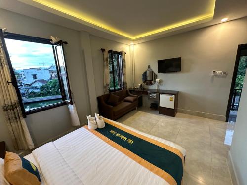 een slaapkamer met een bed, een bank en een raam bij Villa Mahasok hotel in Luang Prabang