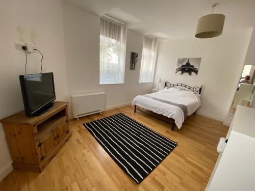 1 dormitorio con 1 cama y TV de pantalla plana en Midland apartments- Open plan, en Leicester