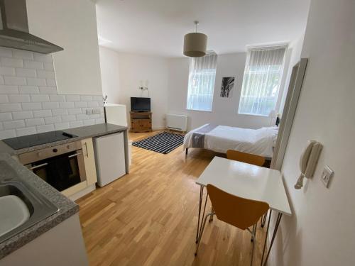 1 dormitorio con 1 cama y cocina con fregadero en Midland apartments- Open plan, en Leicester