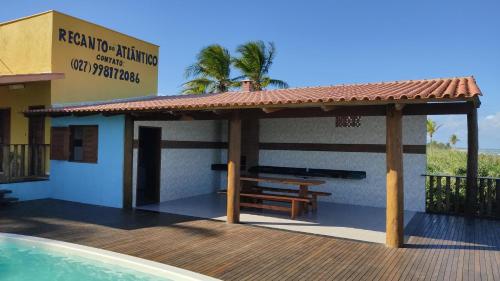 een gebouw met een picknicktafel en een zwembad bij Casa de Praia Recanto do Atlântico in Nova Viçosa