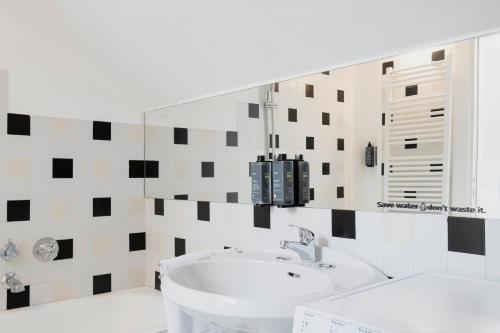 łazienka z umywalką i lustrem w obiekcie RELSTAY - Arco della Pace - Sunny Loft w Mediolanie