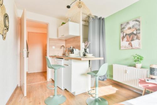 a kitchen with a counter and chairs in a room at Parking - Le Studio - Tramway in Strasbourg