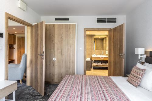 a bedroom with a bed and a bathroom at Hotel Aquarion Family & Friends - Destigo Hotels in Zakopane