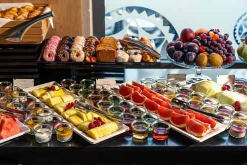 a buffet of fruit and pastries on a table at Hotel Aquarion Family & Friends - Destigo Hotels in Zakopane