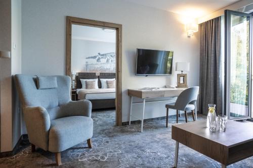 a living room with a chair and a television at Hotel Aquarion Family & Friends - Destigo Hotels in Zakopane