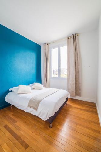 une chambre avec un grand lit avec un mur bleu dans l'établissement Le Général d'Or - 2 Chambres, à Brive-la-Gaillarde