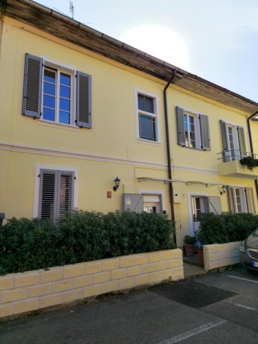 a yellow house with black shutters on it at Benvenuto in Venegono Superiore