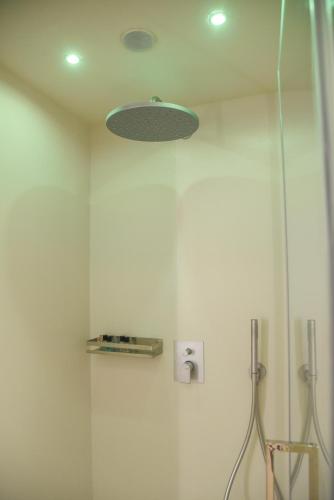 a bathroom with a shower with a light on the ceiling at Shanti Rooms & Apartments Risorgimento in Bacoli