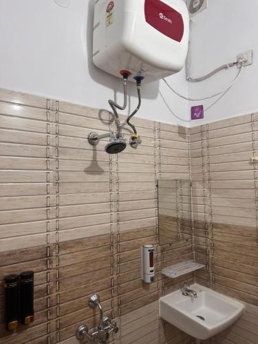 a bathroom with a sink and a hair dryer on the wall at The Peninsulla in Rishīkesh