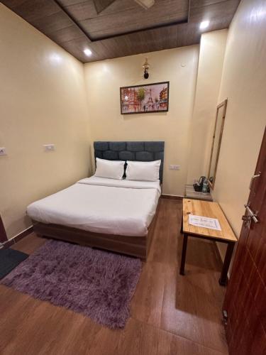 a bedroom with a large bed and a table at The Peninsulla in Rishīkesh