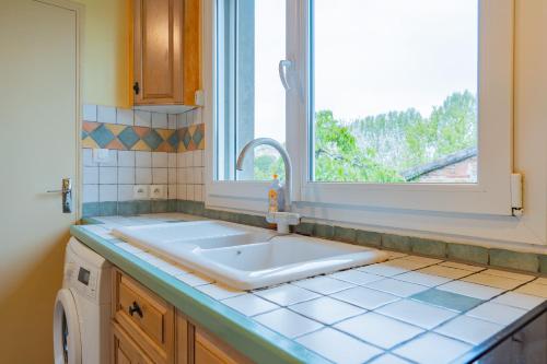 une cuisine avec un évier et une fenêtre dans l'établissement Room in Toulouse - Studio proche Airbus Toulouse St Martin Touch, à Toulouse