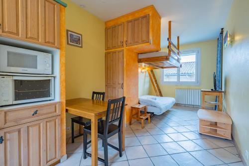 - une cuisine et une salle à manger avec une table et un four micro-ondes dans l'établissement Room in Toulouse - Studio proche Airbus Toulouse St Martin Touch, à Toulouse