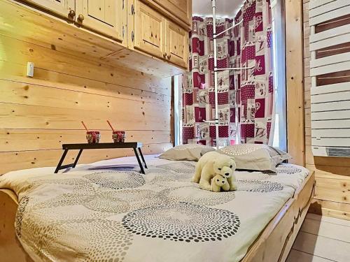 a teddy bear sitting on a bed in a room at Appartement Tignes-Le Lavachet, 2 pièces, 4 personnes - FR-1-411-746 in Tignes