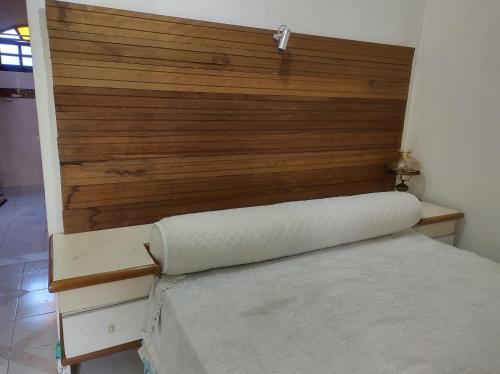 a bed in a room with a wooden headboard at Mi Casa Rio Garagem Wi-Fi Grátis Próximo Praia Barra in Rio de Janeiro