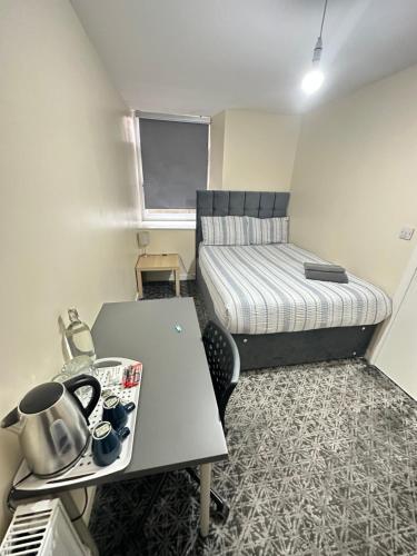 a small room with a table and a bed at Rangers GuestHouse in Glasgow