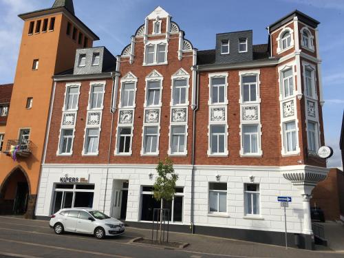 un edificio con un coche aparcado delante de él en Hotel Markt 5 - inmitten der Lübbecker Altstadt, kostenloser Parkplatz direkt am Hotel, en Lübbecke