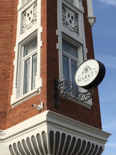 a building with a sign on the side of it at Hotel Markt 5 - inmitten der Lübbecker Altstadt, kostenloser Parkplatz direkt am Hotel in Lübbecke