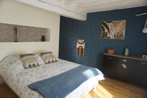 a bedroom with a bed and a blue wall at Le Domaine du Moulin 28 proche Chartres in Bailleau-lʼÉvêque