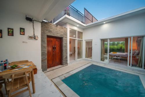 an indoor swimming pool in a house with a table at Modern Cozy Private Villa with 2Br Rooftop Sunset and Vineyard View in Banjar