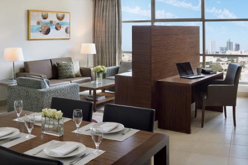 a dining room with a table with a laptop on it at Marriott Executive Apartments Al Khobar in Al Khobar