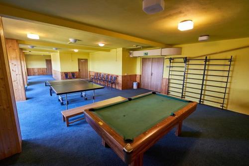 una habitación con dos mesas de ping pong. en Apartmán Žalý, en Benecko