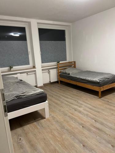two beds in a room with two windows at Unterkunft NRW ID1 in Leverkusen