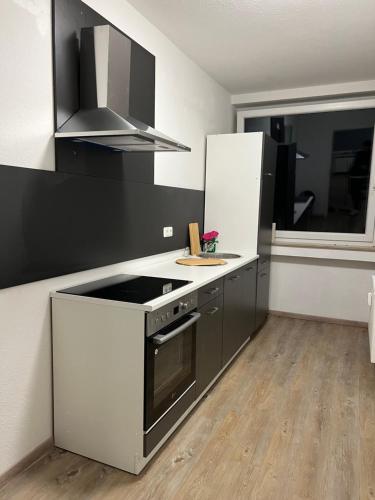 a kitchen with a black and white stove and refrigerator at Unterkunft NRW ID1 in Leverkusen