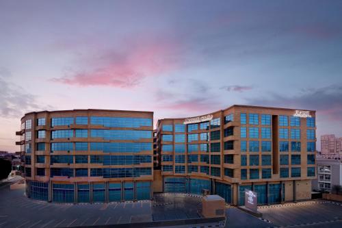 two tall buildings in a city with a cloudy sky at Marriott Executive Apartments Al Khobar in Al Khobar