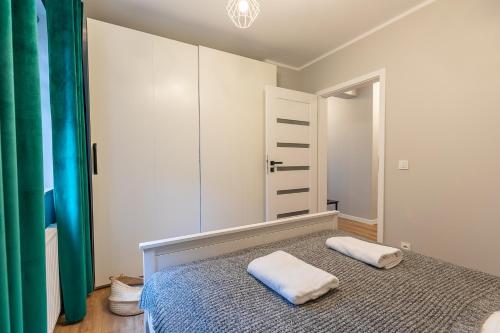sypialnia z łóżkiem z dwoma ręcznikami w obiekcie RentPlanet - Apartamenty Izerska w Szklarskiej Porębie