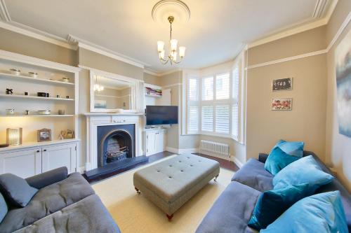 a living room with two couches and a fireplace at House - Sleeps 8 - Garden - Children's Play Area in London