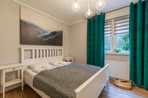 um quarto com uma cama com cortinas verdes em RentPlanet - Apartamenty Izerska em Szklarska Poręba