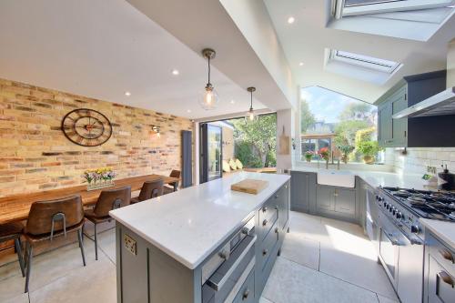 a kitchen and dining room with a brick wall at House - Sleeps 8 - Garden - Children's Play Area in London