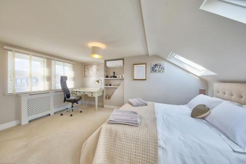 a bedroom with a bed and a desk and a chair at Family 4-Bed House & Secluded Garden - Wimbledon in London